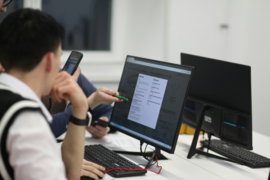 a-group-of-people-sitting-at-a-table-with-computers.jpg A group of people sitting at a table with computers